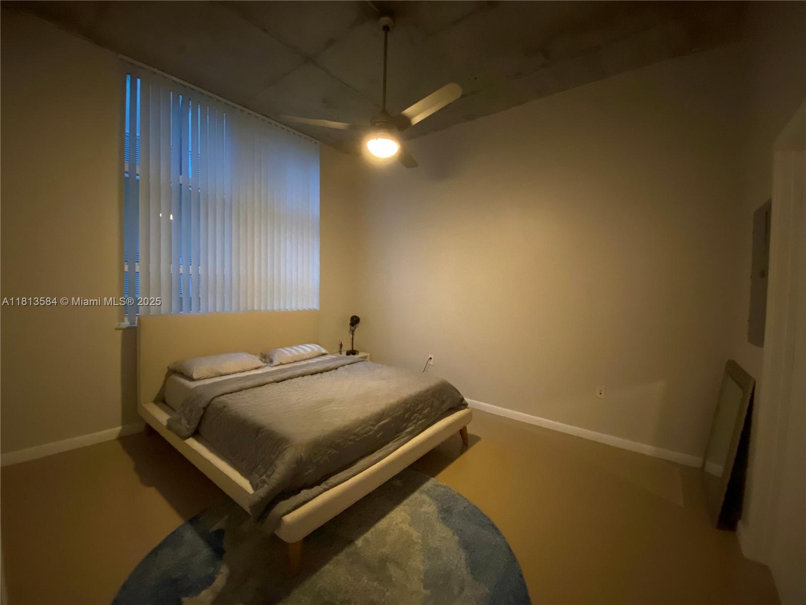 2001 Biscayne Boulevard, Unit 3203 Miami, FL 33137 - Photo 9 of 15 a bedroom with a bed and a chandelier