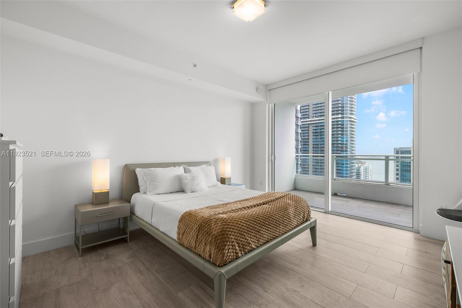 1080 Brickell Avenue, Unit 3602 Miami, FL 33131 - Photo 23 of 45 a bedroom with a bed lamp and a large window