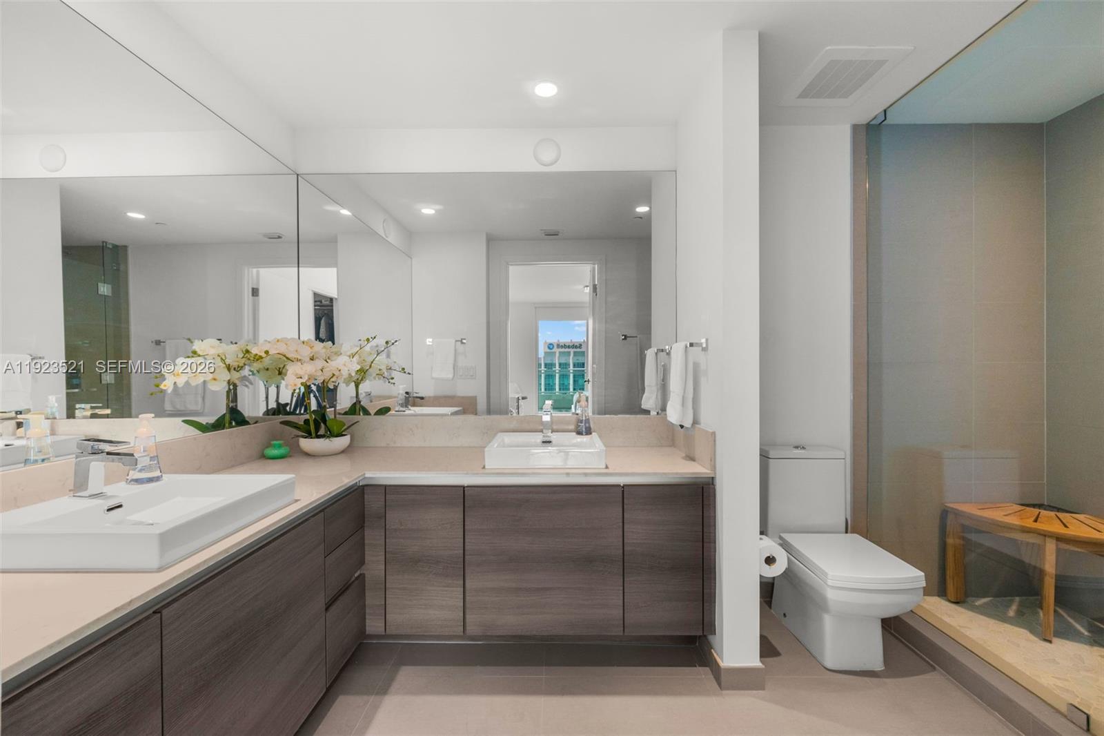1080 Brickell Avenue, Unit 3602 Miami, FL 33131 - Photo 30 of 45 a bathroom with a double vanity sink toilet and a mirror