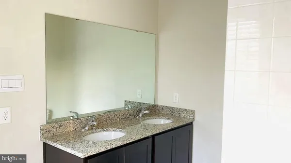 a bathroom with a granite countertop sink and a mirror