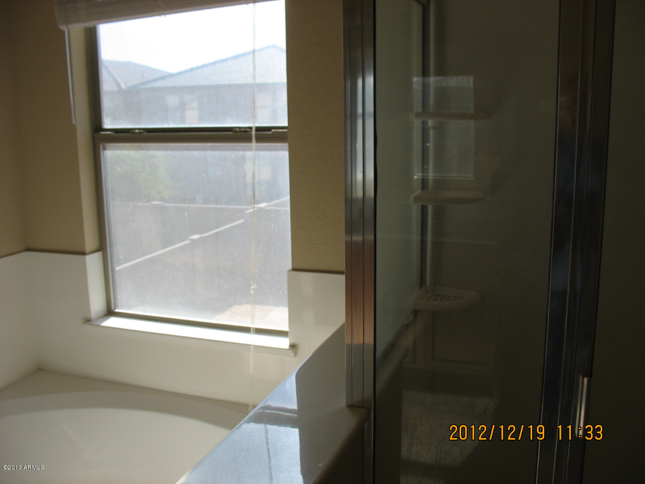 45571 West Guilder Avenue Maricopa, AZ 85139 - Photo 8 of 8 a bathroom with a glass shower door