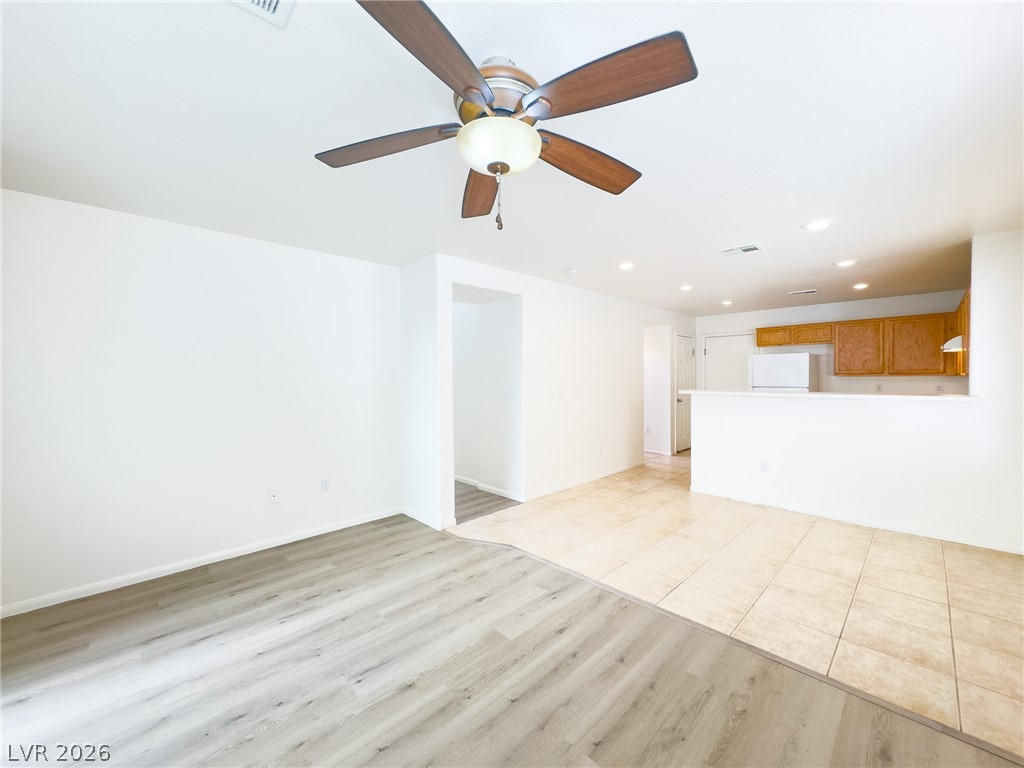 9456 Grandview Spring Avenue Las Vegas, NV 89166 - Photo 11 of 49 A versatile open-concept space featuring both wood plank and tile flooring, complete with an integrated kitchen area.