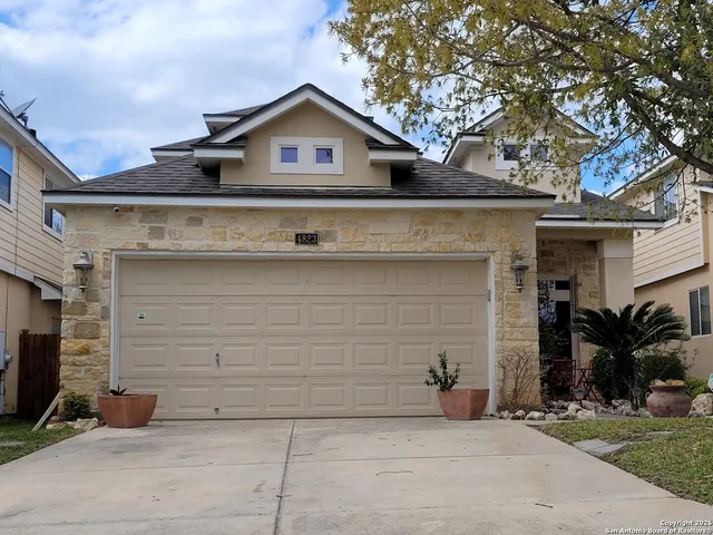 a view of a white house with large windows and a tree