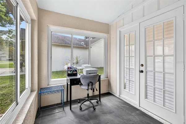 a view of a workspace with furniture and a window