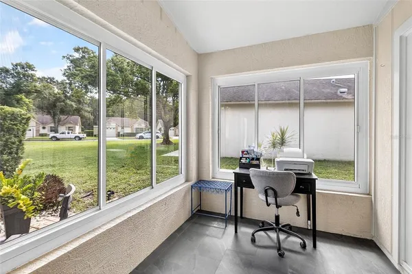 a view of a workspace with a large window and sitting area