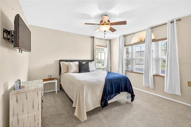 a spacious bedroom with a bed and a chandelier