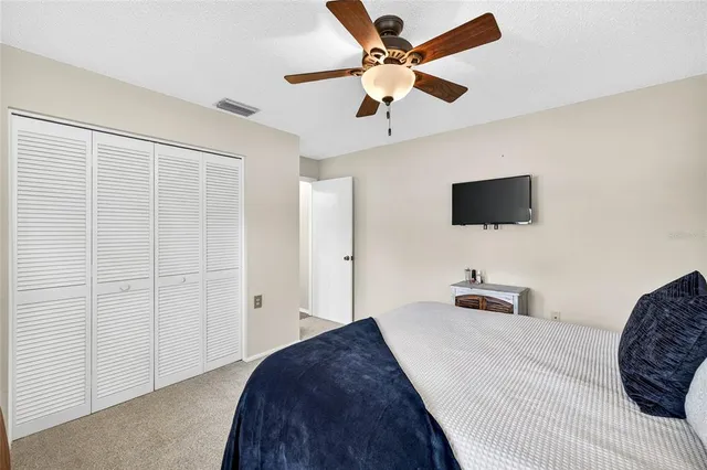 a bedroom with a bed a flat screen tv and a chandelier