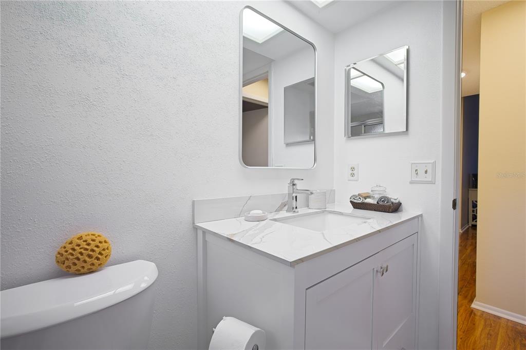 4658 Wallingford Court New Port Richey, FL 34655 - Photo 19 of 48 a bathroom with a toilet sink vanity and mirror