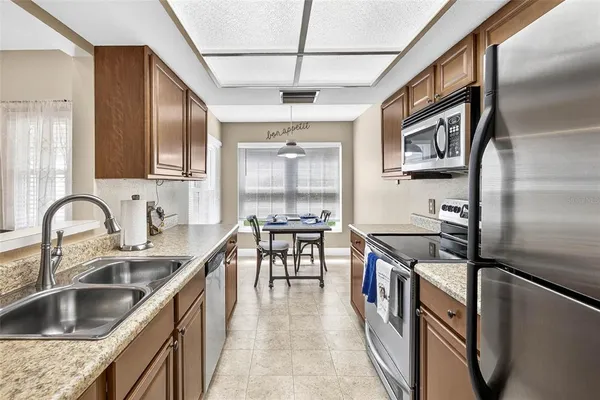 a kitchen with stainless steel appliances granite countertop a sink and a refrigerator