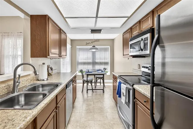 a kitchen with stainless steel appliances granite countertop a sink and a refrigerator