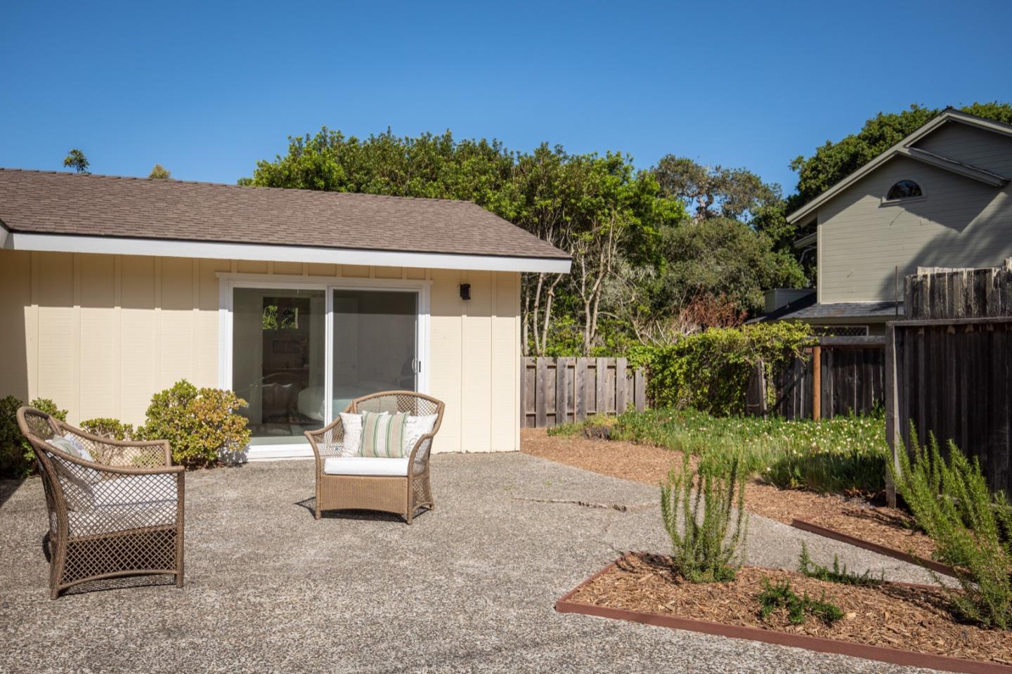 1043 Ocean Road Pebble Beach, CA 93953 - Photo 13 of 18 a wooden bench sitting in front of a house
