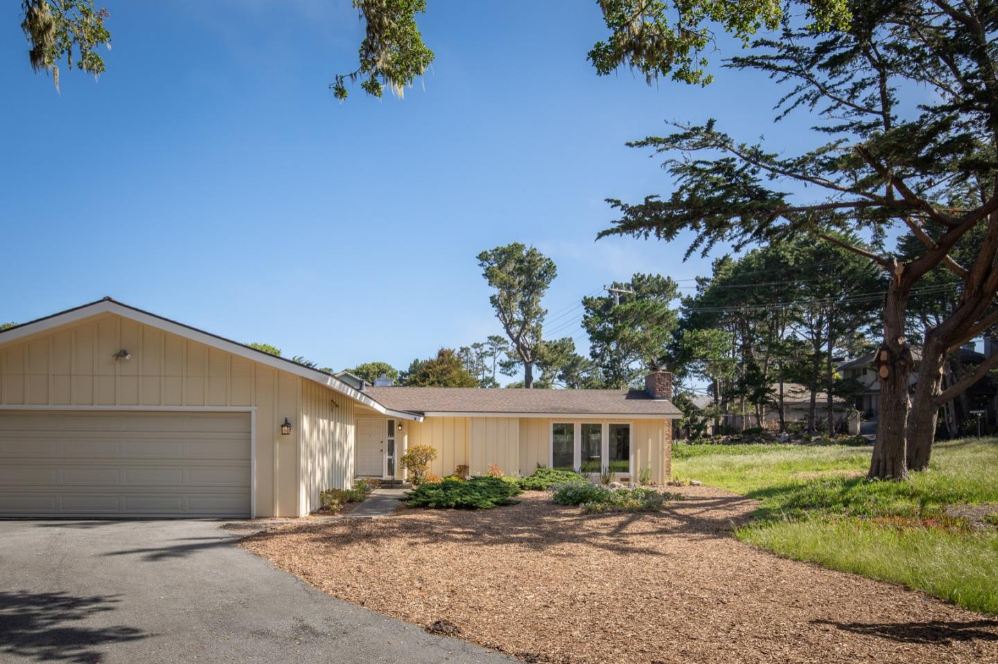 1043 Ocean Road Pebble Beach, CA 93953 - Photo 18 of 18 a front view of a house with a yard and a garage