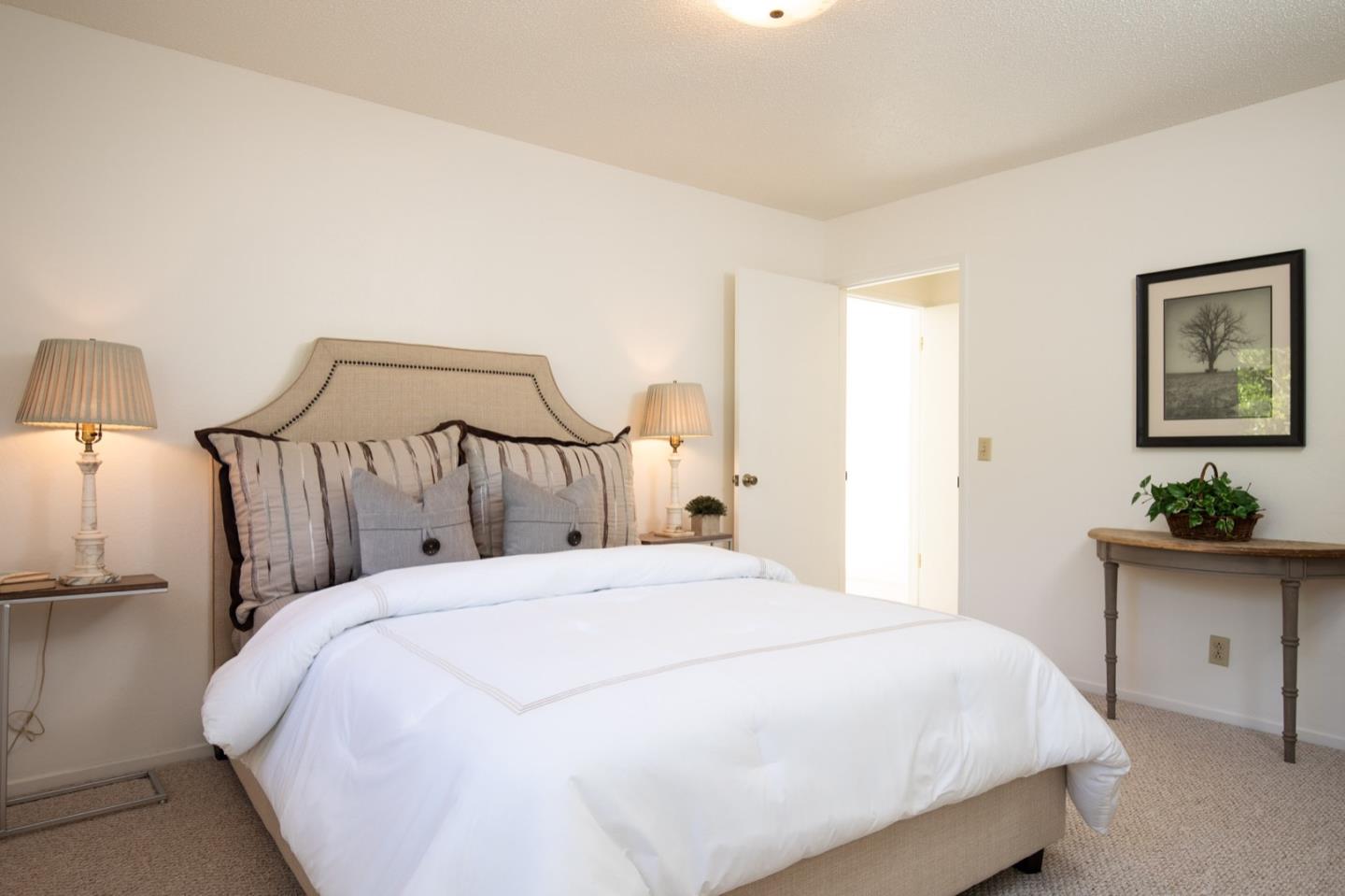 1043 Ocean Road Pebble Beach, CA 93953 - Photo 10 of 18 a large bed sitting in a bedroom and a table