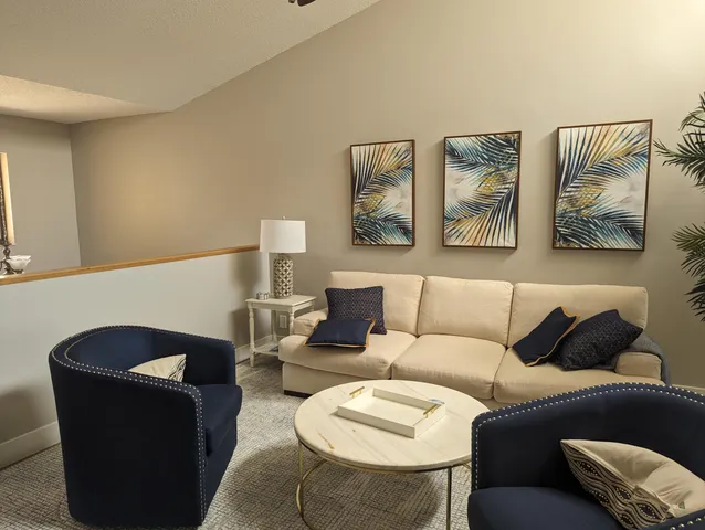 a living room with furniture and painting on the wall