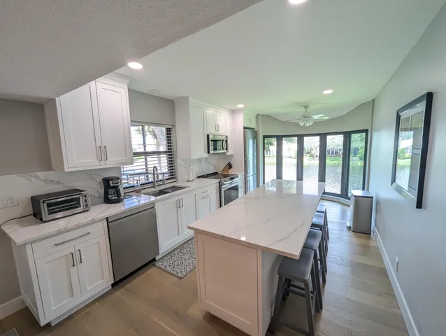a kitchen with white cabinets and sink