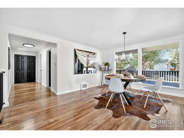 a view of a dining room with furniture a chandelier and wooden floor