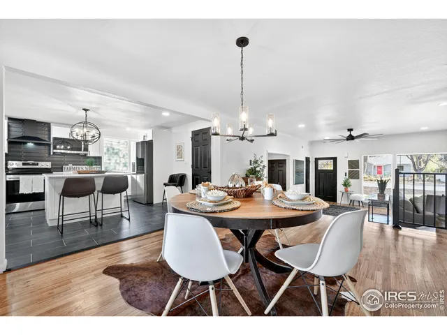a dining room with furniture a chandelier and wooden floor