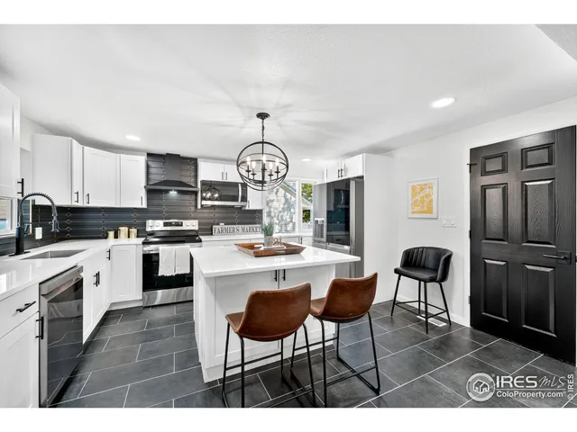 a open kitchen with stainless steel appliances granite countertop a stove a sink a dining table and chairs