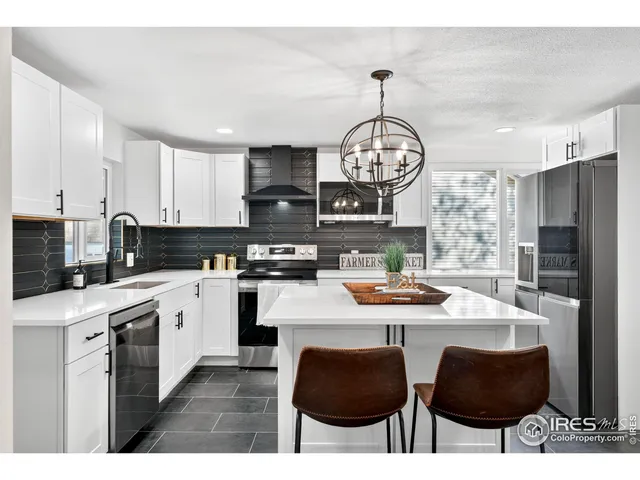 a kitchen with stainless steel appliances a table chairs and a refrigerator