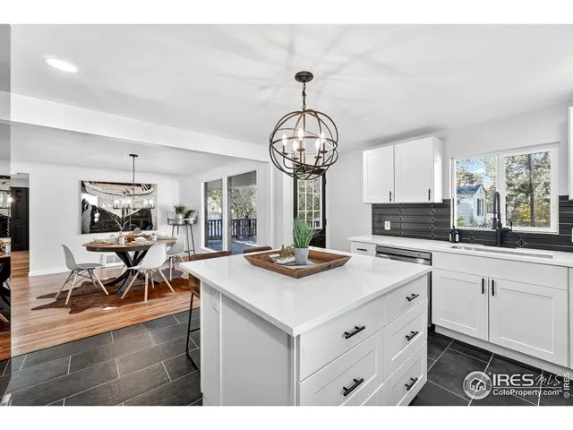 a kitchen with stainless steel appliances kitchen island a table and chairs in it