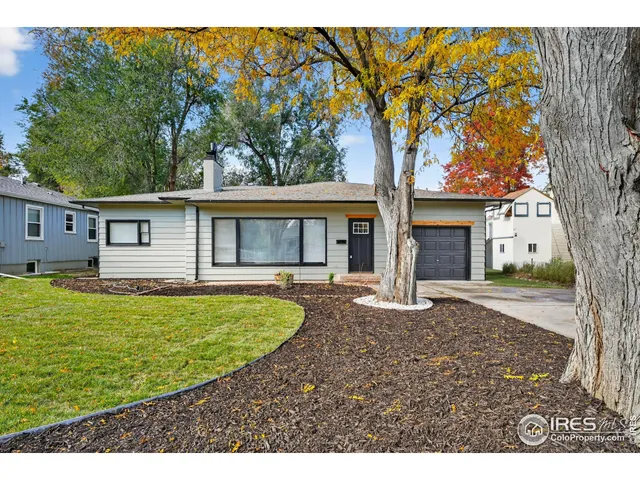 a view of a house with backyard and a tree