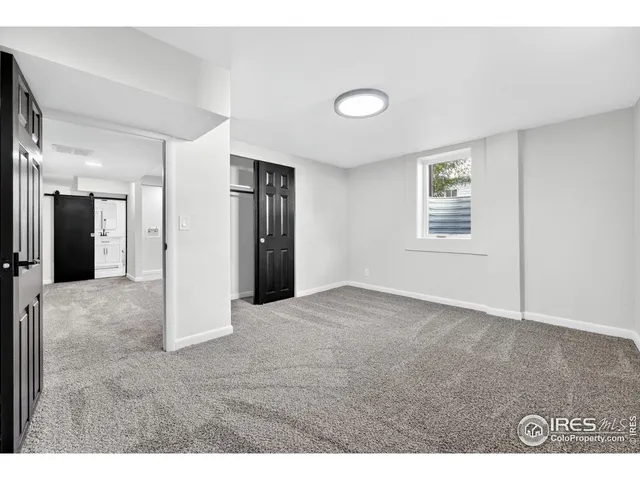 a view of an empty room with closet and window