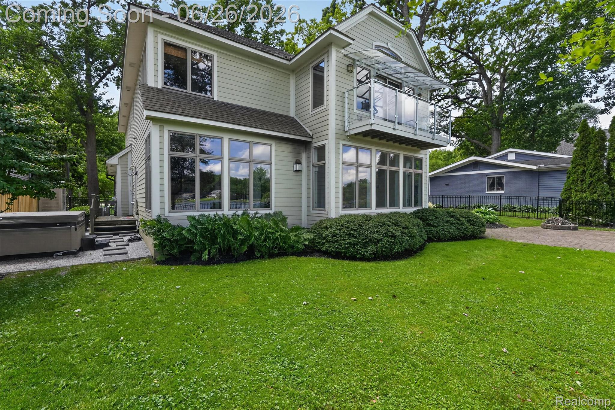 3478 Lexington Road Waterford, MI 48328 - Photo 37 of 52 Two-story residence featuring light-colored siding, a second-story balcony with glass railing, and a ground-level sunroom with multiple windows