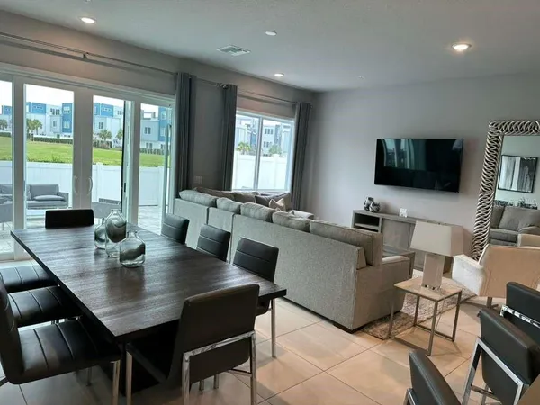 a living room with furniture flat screen tv and a large window