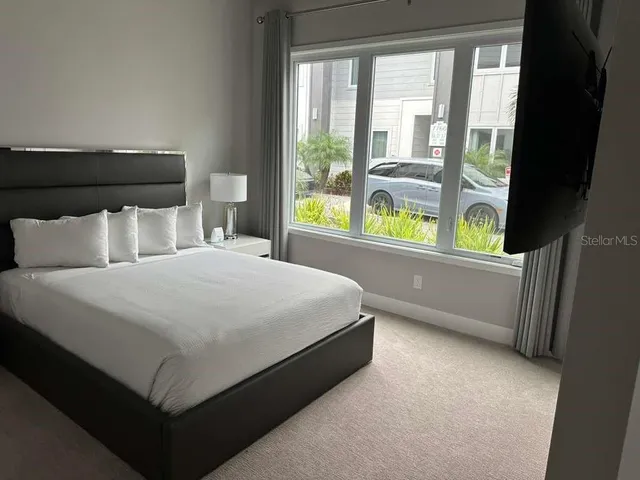 a bed sitting in a bedroom next to a window