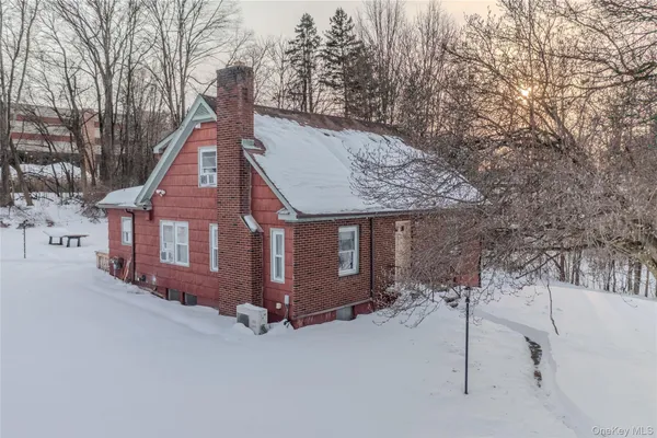 a view of a house with a yard and large tree