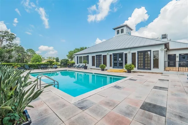 a view of house with swimming pool outdoor seating