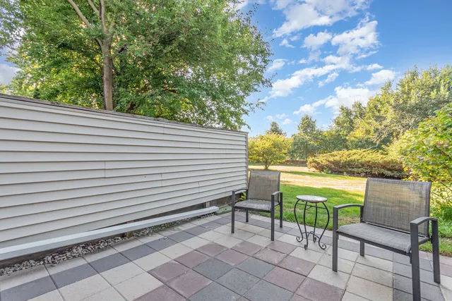 a view of a chairs and table in the back yard of the house