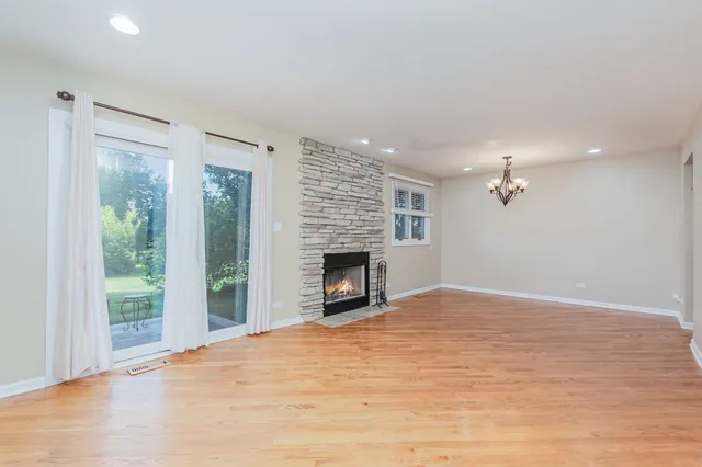 a view of an empty room with a fireplace and a window