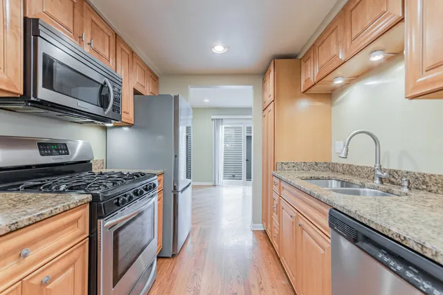 a kitchen with stainless steel appliances granite countertop a stove and a microwave