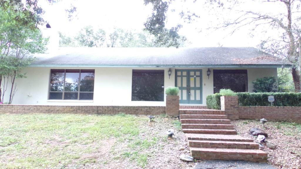 34311 Blanton Road Dade City, FL 33523 - Photo 1 of 1 a front view of a house with a garden and plants