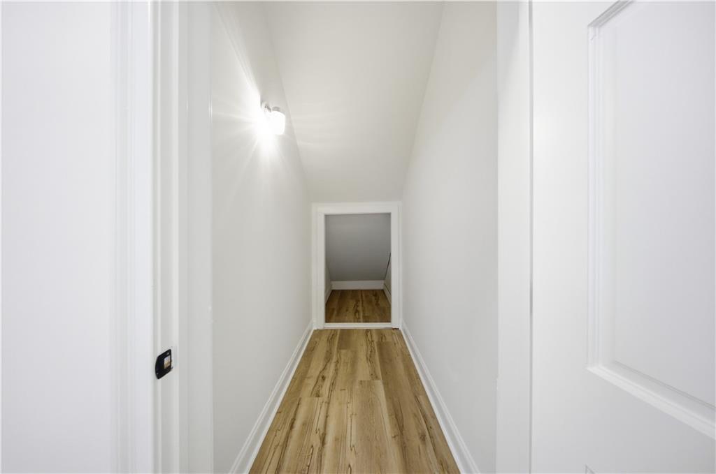2390 Peachtree Road Cumming, GA 30041 - Photo 55 of 82 a view of a hallway with wooden floor and a bathroom