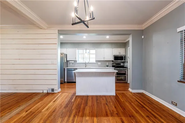 a kitchen with stainless steel appliances granite countertop a sink cabinets and wooden floor