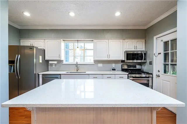 a kitchen with stainless steel appliances a refrigerator sink and cabinets