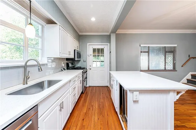 a kitchen with a sink stove and cabinets