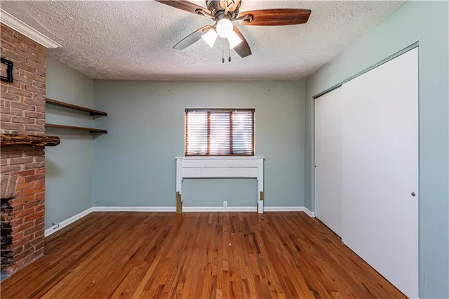 a view of a livingroom with wooden floor and a fireplace
