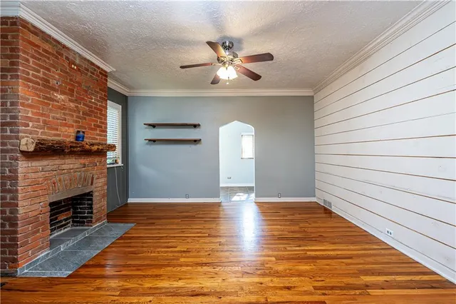 a view of empty room with wooden floor and fireplace