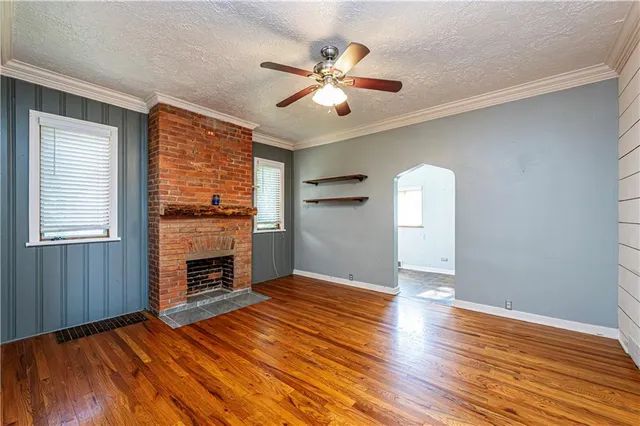 a view of empty room with wooden floor and fireplace