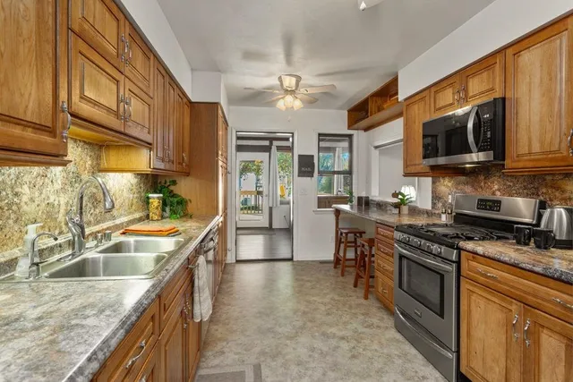 a kitchen with stainless steel appliances granite countertop a sink stove and refrigerator