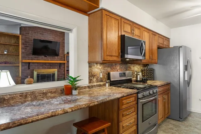 a kitchen with granite countertop a sink stove and refrigerator