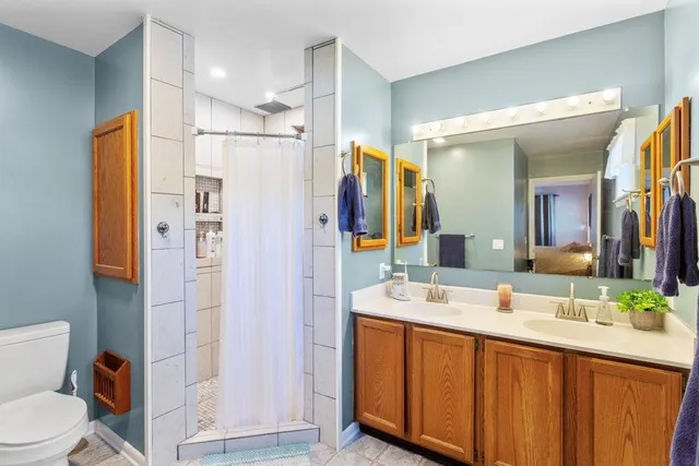 a bathroom with a double vanity sink toilet and shower