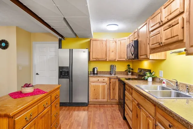 a kitchen with granite countertop stainless steel appliances a stove refrigerator and cabinets
