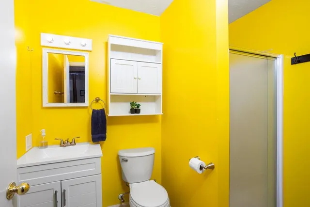 a bedroom with a bed and a dresser with wooden floor