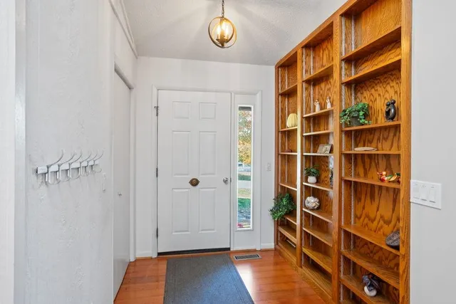 a view of empty room with wooden floor and closet