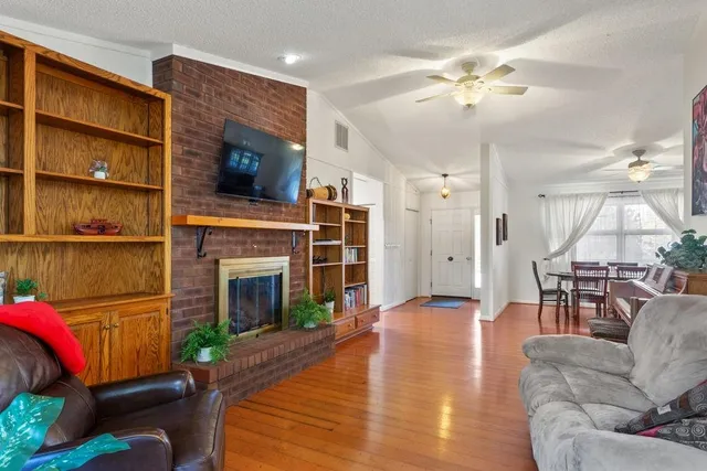 a living room with furniture a fireplace and a chandelier