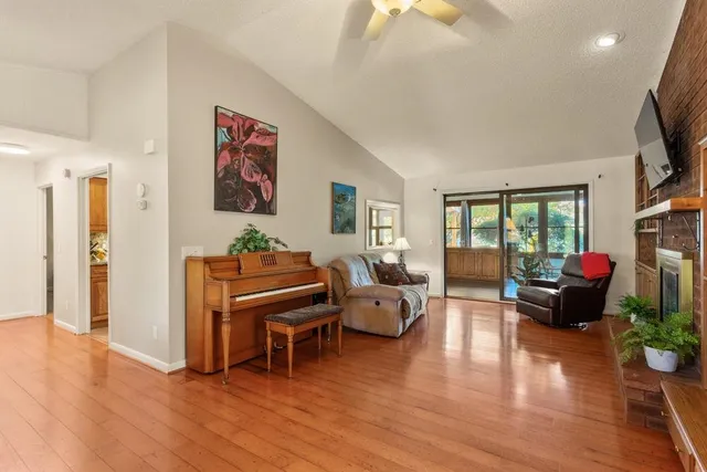 a living room with furniture flat screen tv and wooden floor